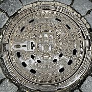 Attractive cast iron manhole cover featuring the City crest in the centre of Prague (Praha) Prazska Kanalizace means Prague Sewerage Board